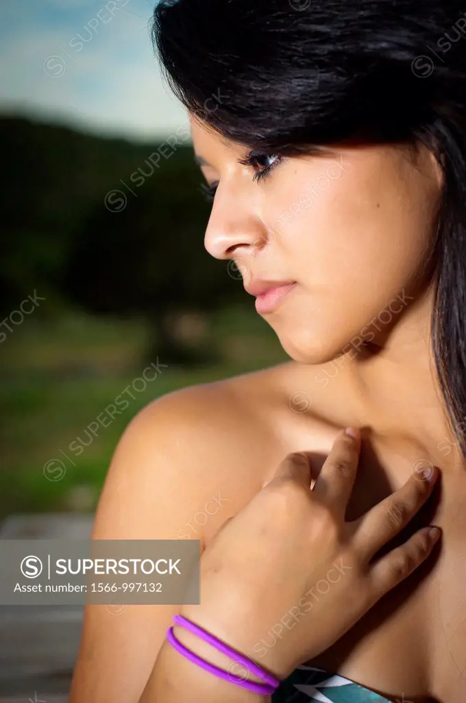 Beautiful young hispanic woman posing outdoors in summer dress