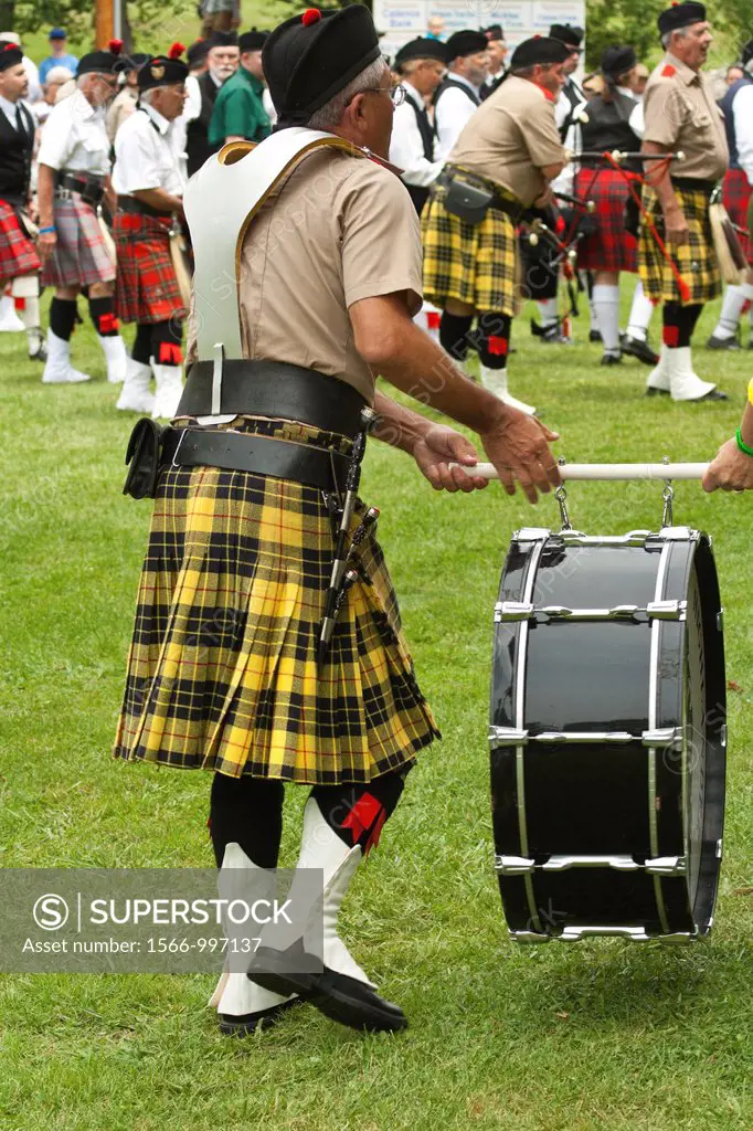 Drummer and piper pratcise at Scottish Highland Festival, Blairsville Georgia USA carries his drum from the field
