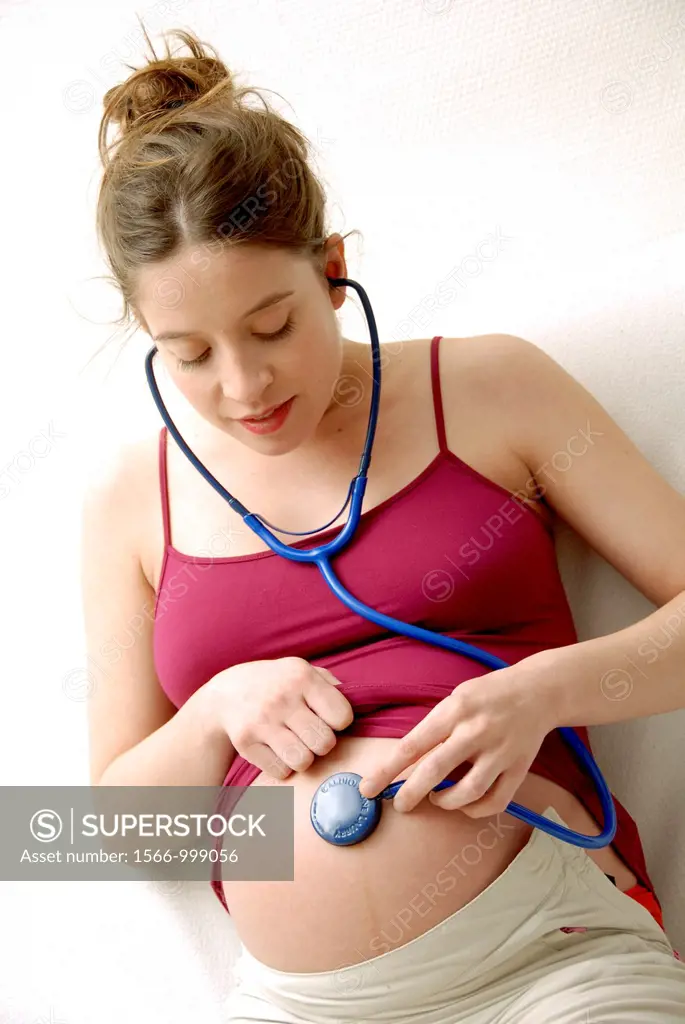 Pregnant woman at full term listening the heart beat of her baby