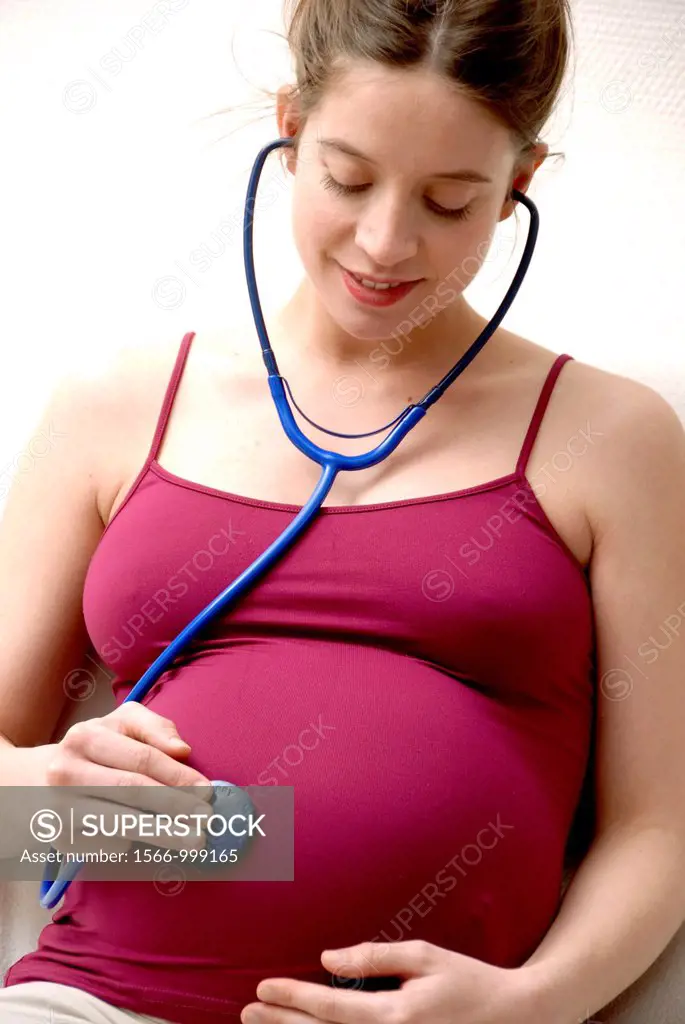 Pregnant woman at full term listening the heart beat of her baby