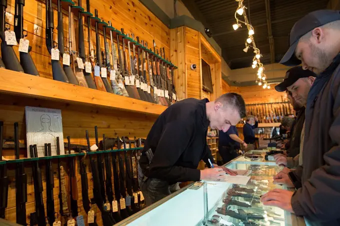 Milford, Michigan - A worker looked over paperwork for a gun buyer´s background check as customers crowded the Huron Valley Guns store on Gun Apprecia...