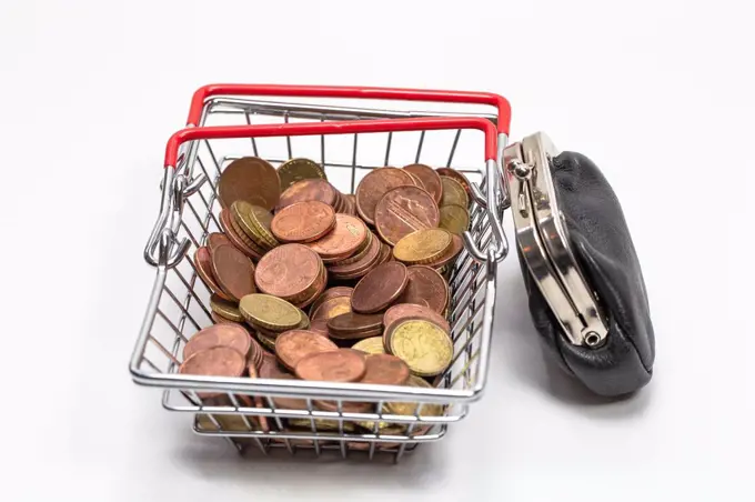 Iron shopping basket filled with euro coins isolated on white background, business and financial concept.