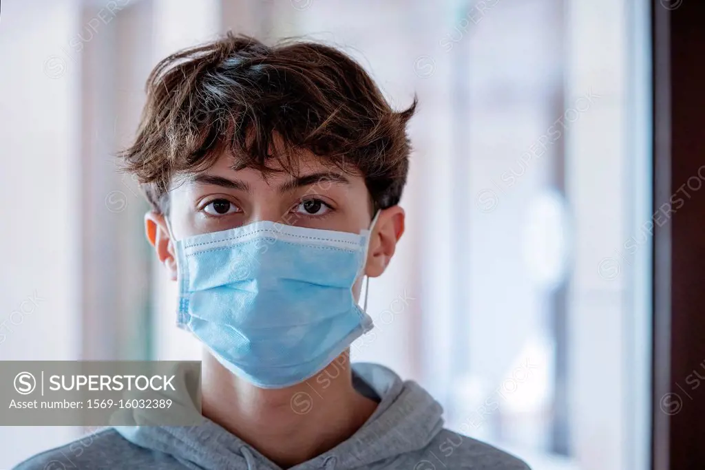 Close up of teenage boy wearing blue surgical mask