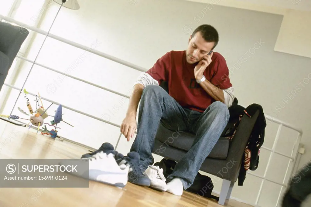 Man putting on shoes and talking on phone
