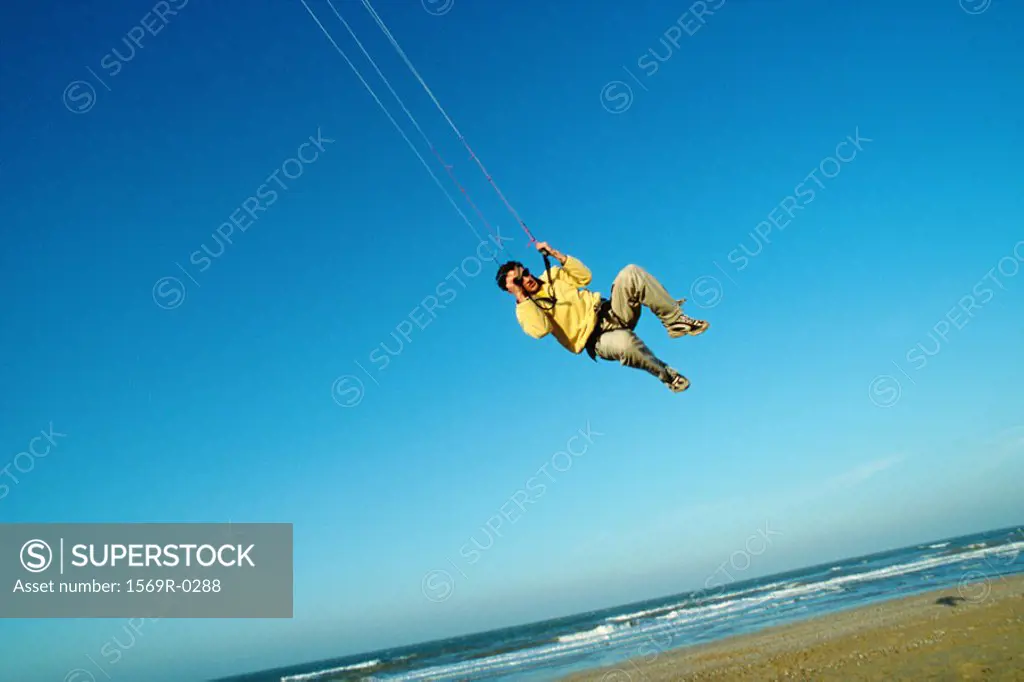 Man in mid air, kitesurfing