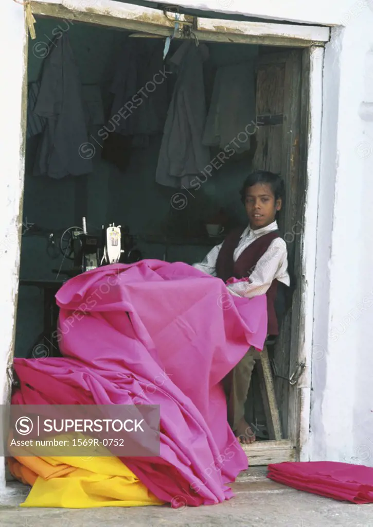 India, Pushkar, boy sewing