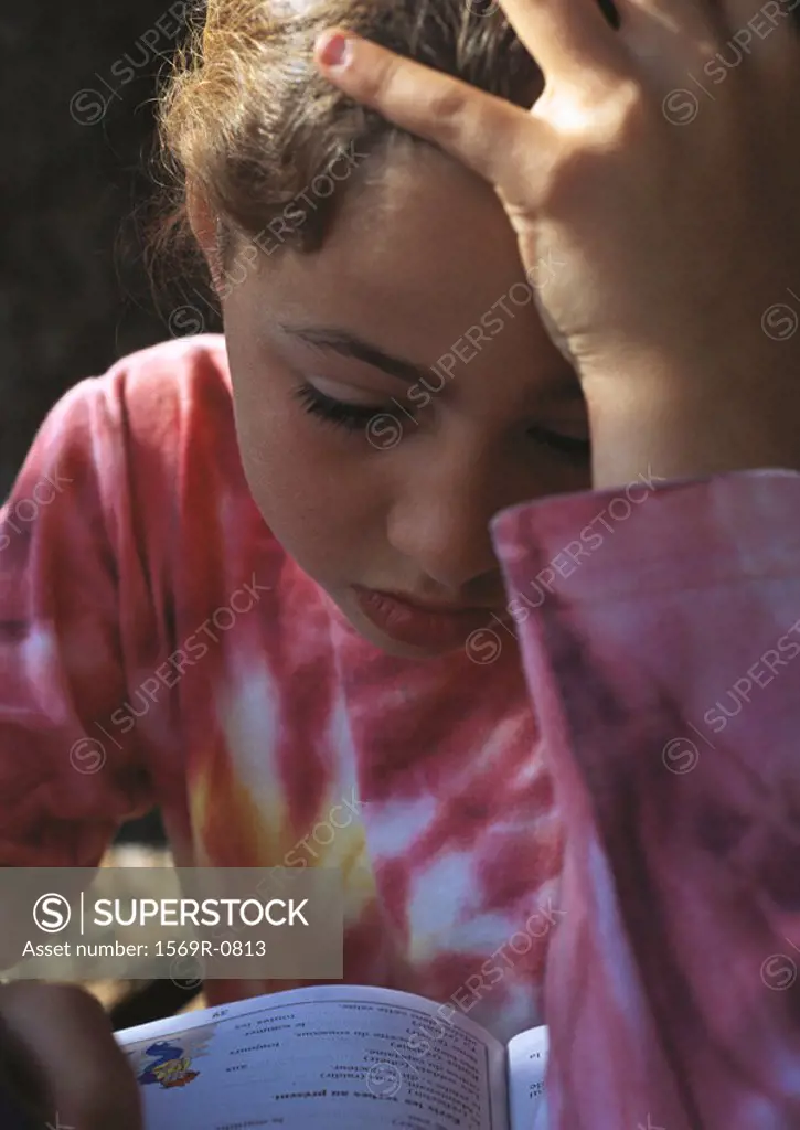 Child doing homework, holding head