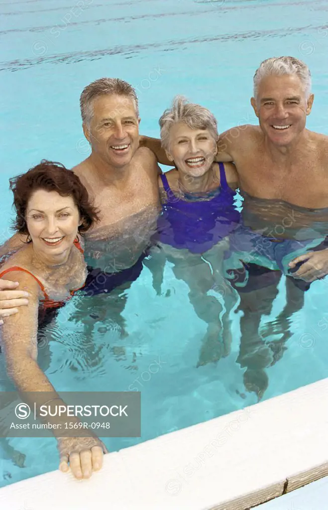 Two mature couples standing in swimming pool