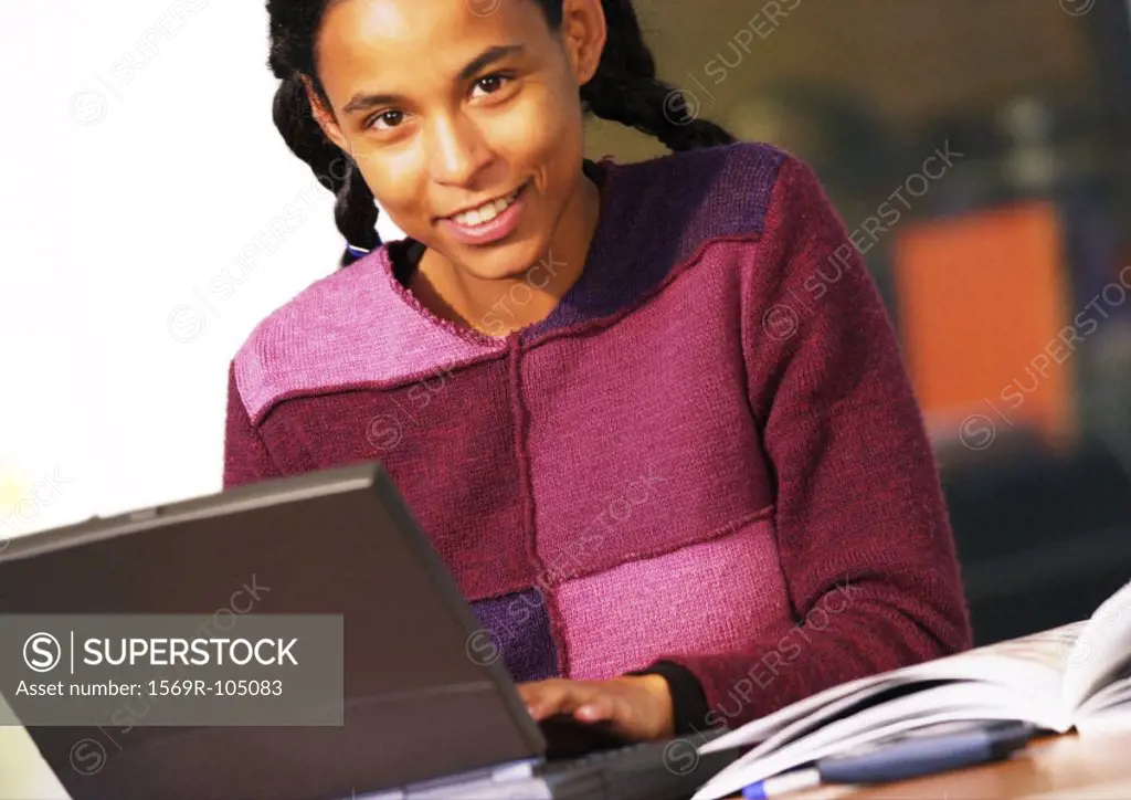Woman with laptop computer, smiling, portrait