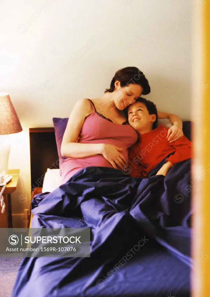 Pregnant woman and child in bed
