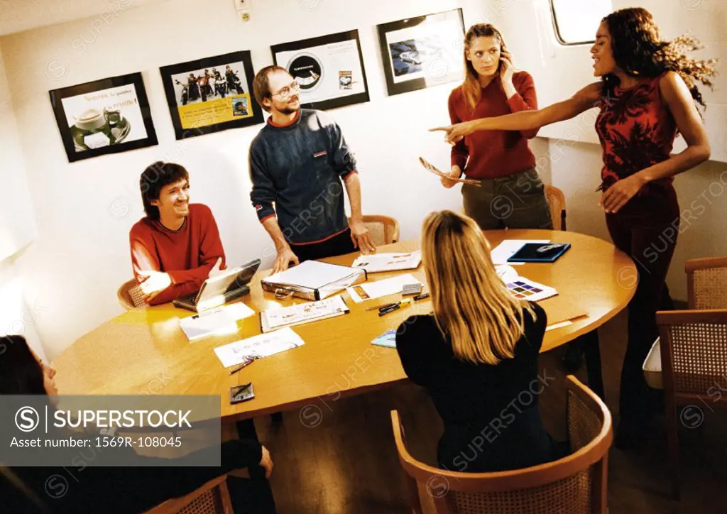 People in conference room, woman pointing finger