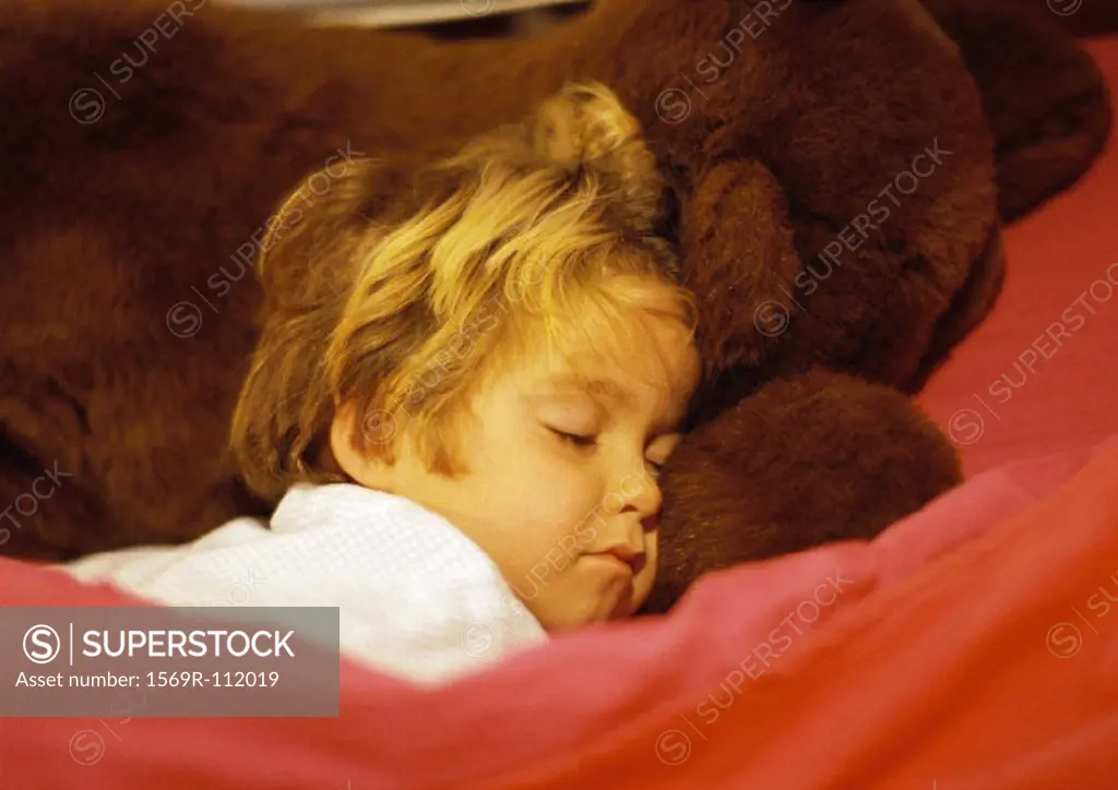 Girl sleeping, head on teddy bear