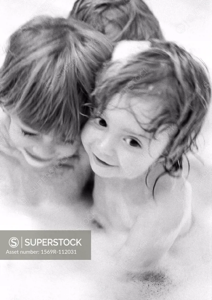 Children in bathtub with suds, close-up, b&w