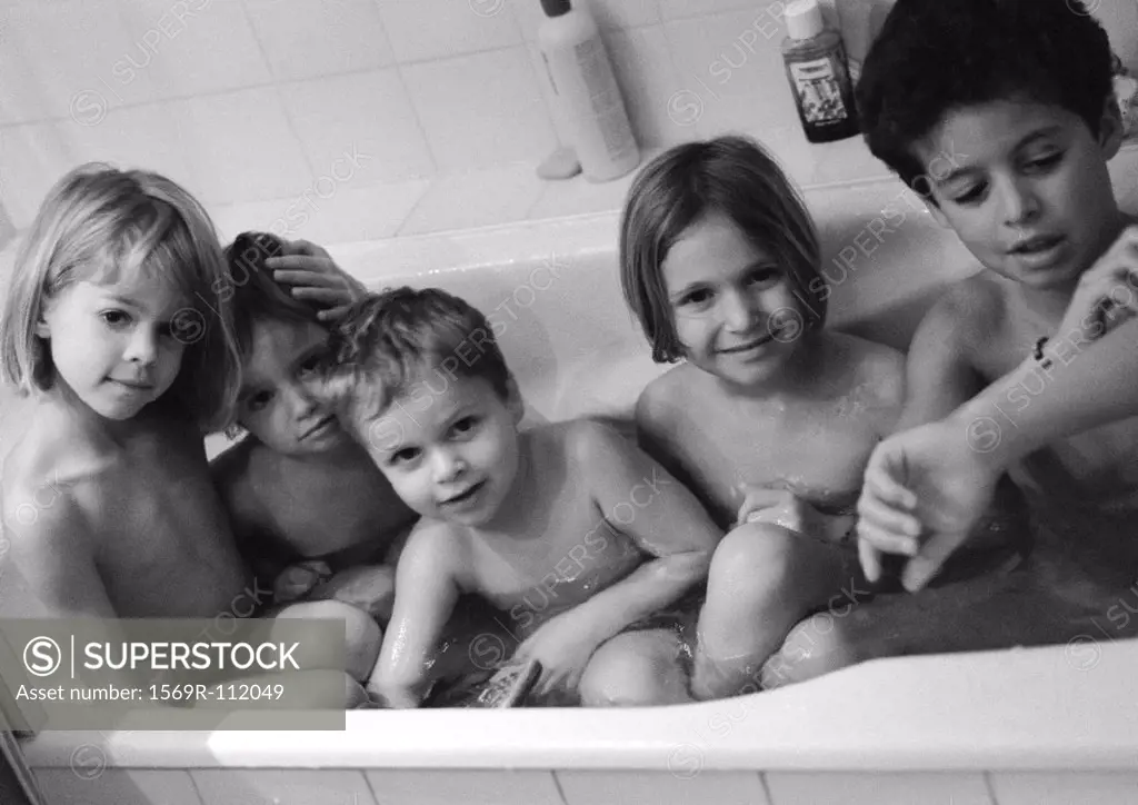 Five children sitting in bathtub, b&w