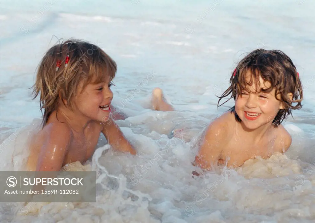 Two girls playing in the water, smiling