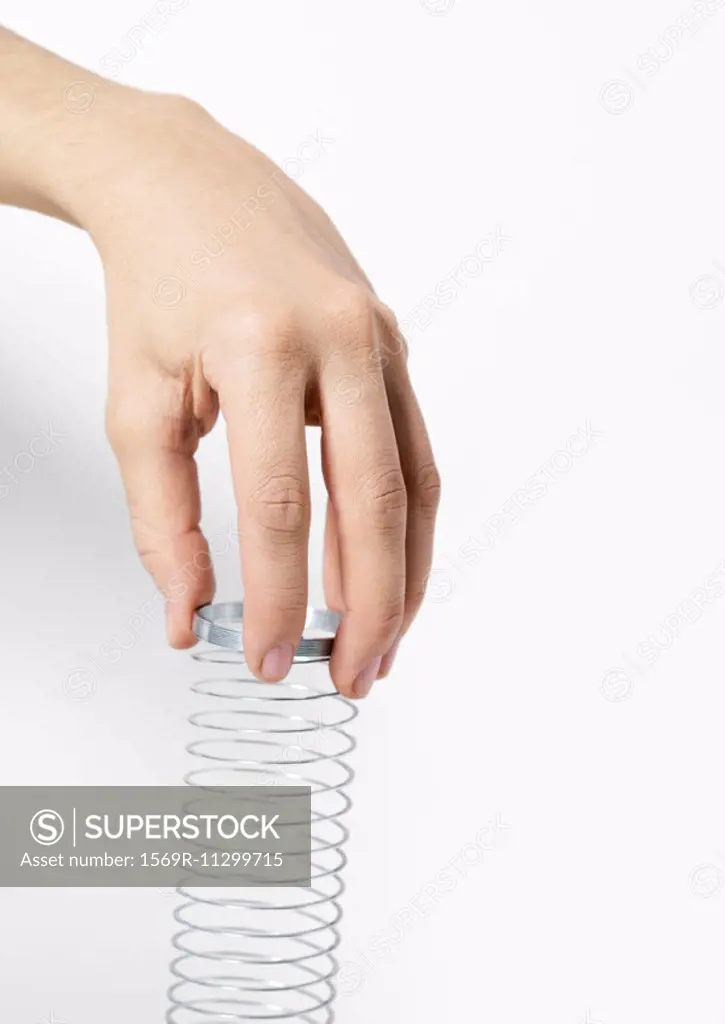 Hand holding metal coil toy