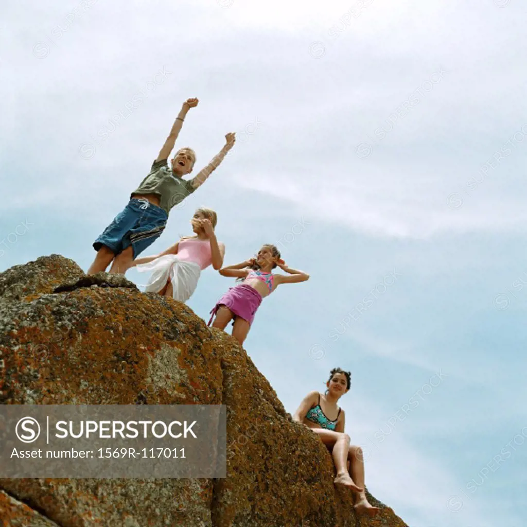 People standing on rock, low angle view
