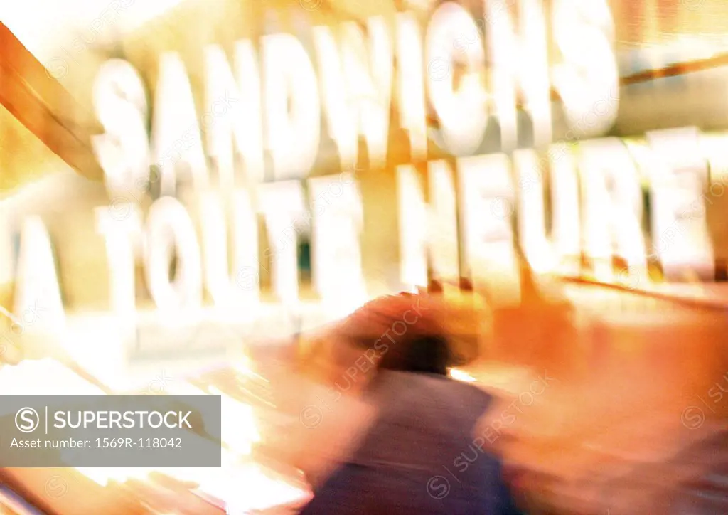 Sign saying ´sandwiches served all day´ in French, blurred