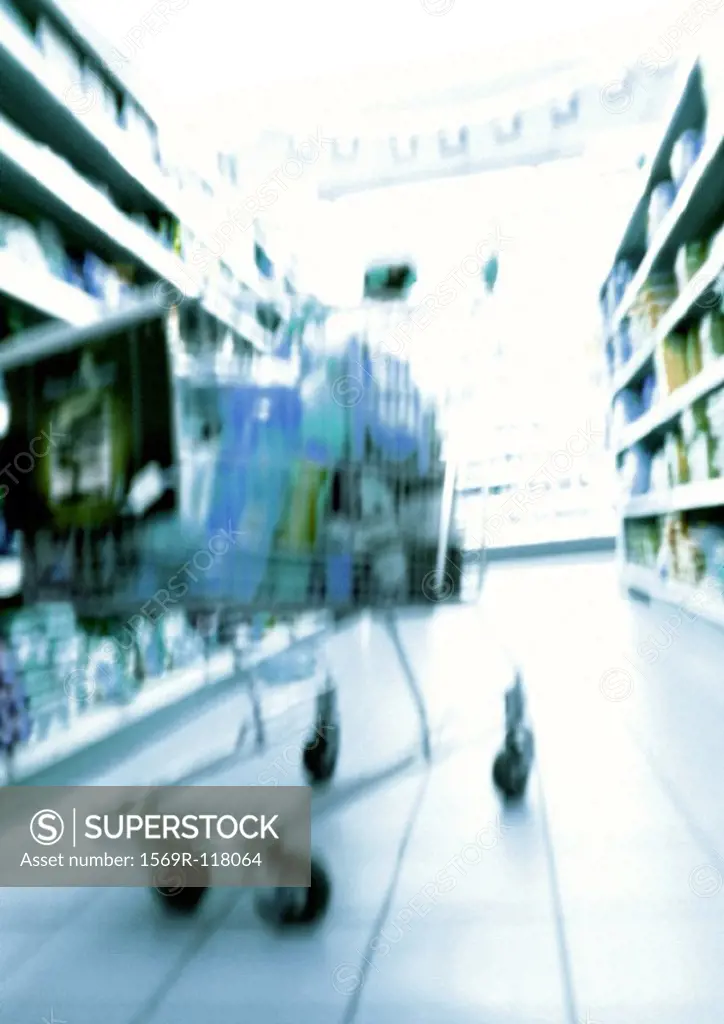 Shopping cart in supermarket, blurred