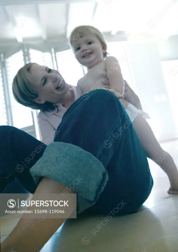 Mother holding baby, smiling, low angle view