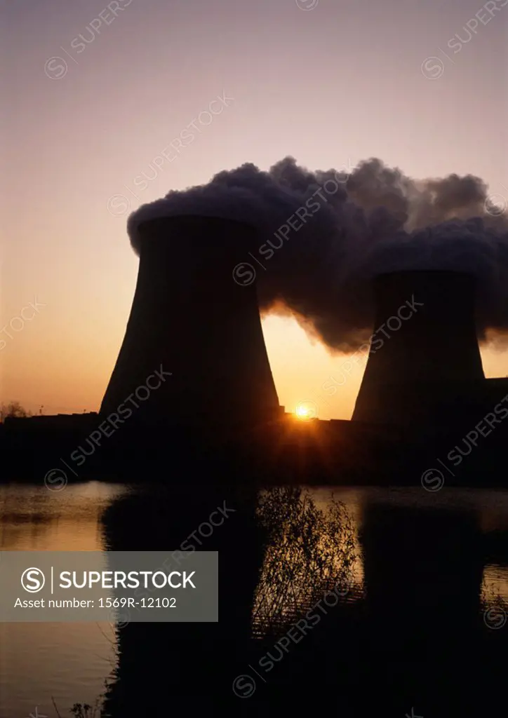 Nuclear reactors reflected in water at sunrise