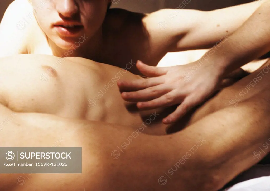 Woman caressing nude man´s stomach, close-up