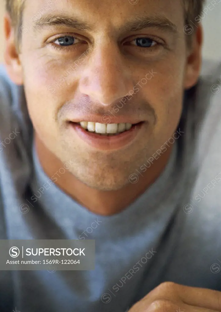 Man looking into camera, smiling, close-up, portrait