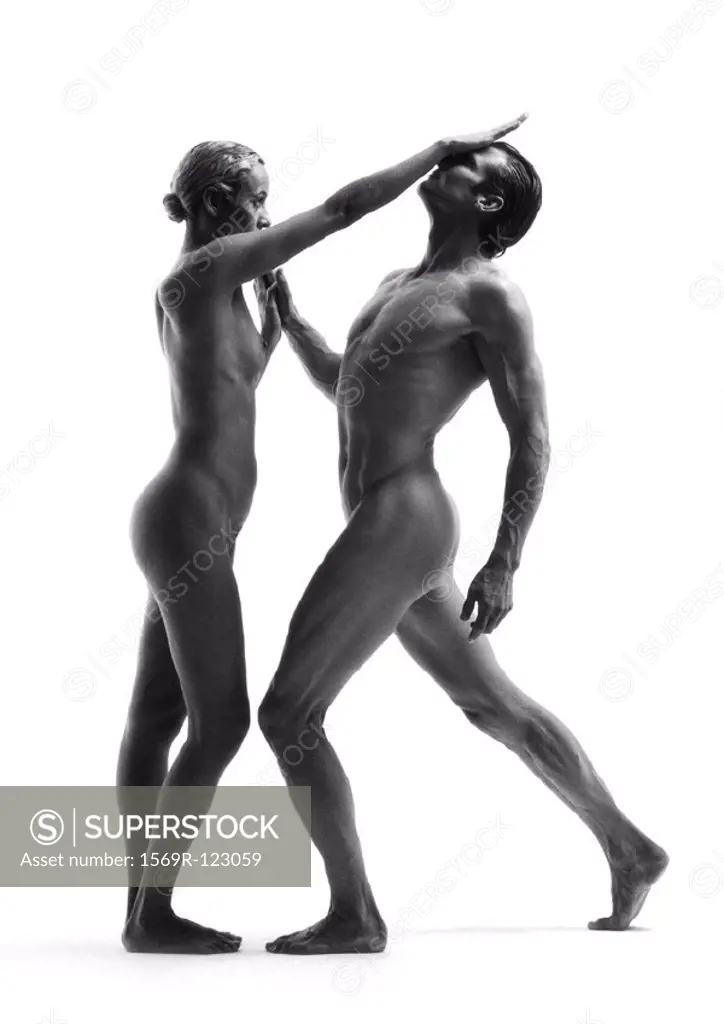 Nude man and woman standing face to face, woman´s forearm against man´s face, side view, b&w