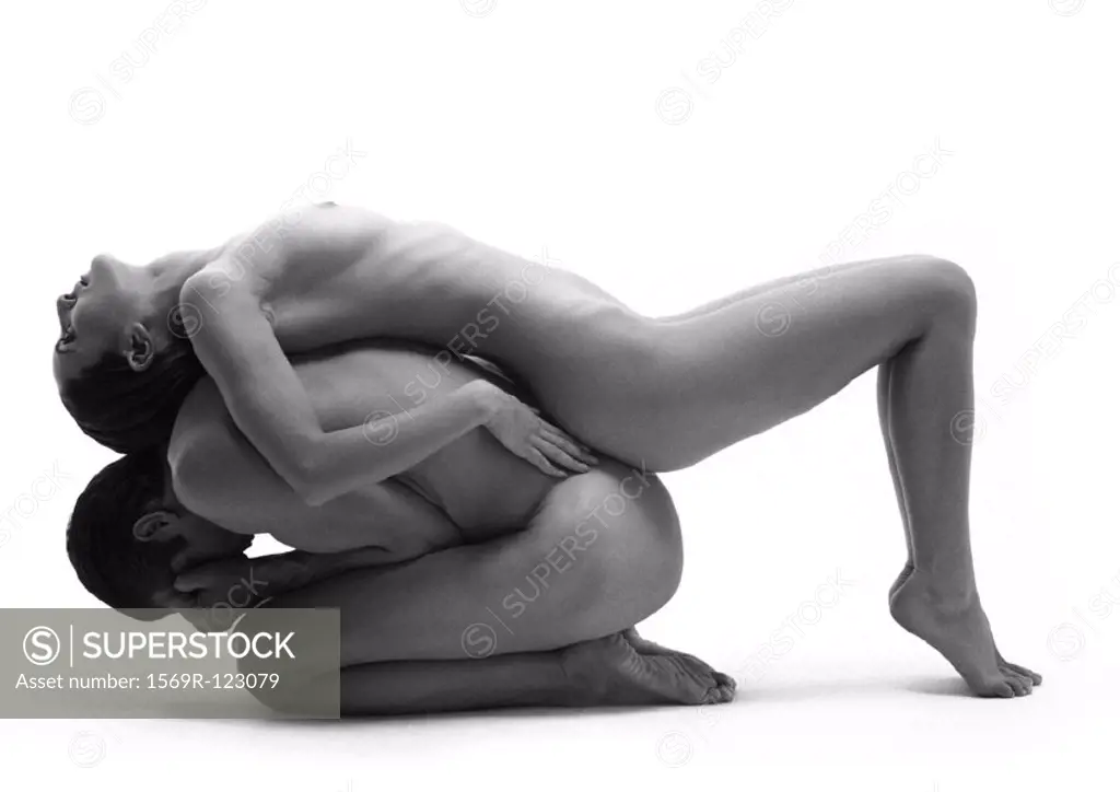 Nude man in fetal position, nude woman lying across man´s back, side view, b&w