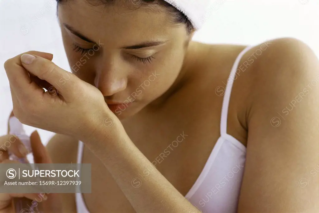 Young woman trying on perfume