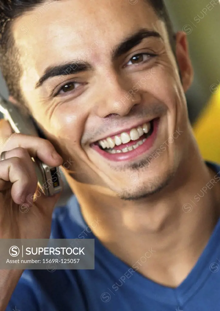 Man using cell phone, smiling, close-up