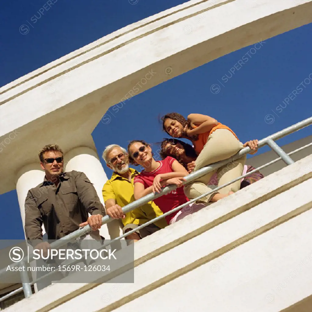 Family leaning on railing, low angle view