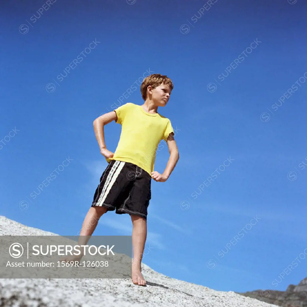 Boy standing with hands on hips, low angle view