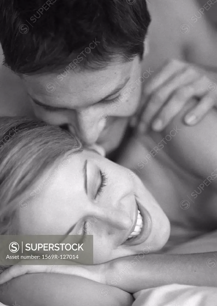 Couple lying on bed, close-up, b&w