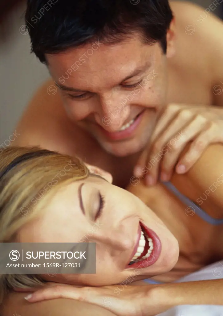 Couple lying on bed, smiling