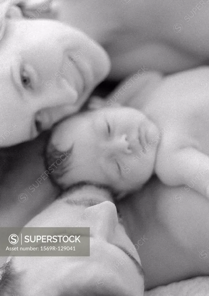 Mother and father with infant, close-up, high angle view, b&w