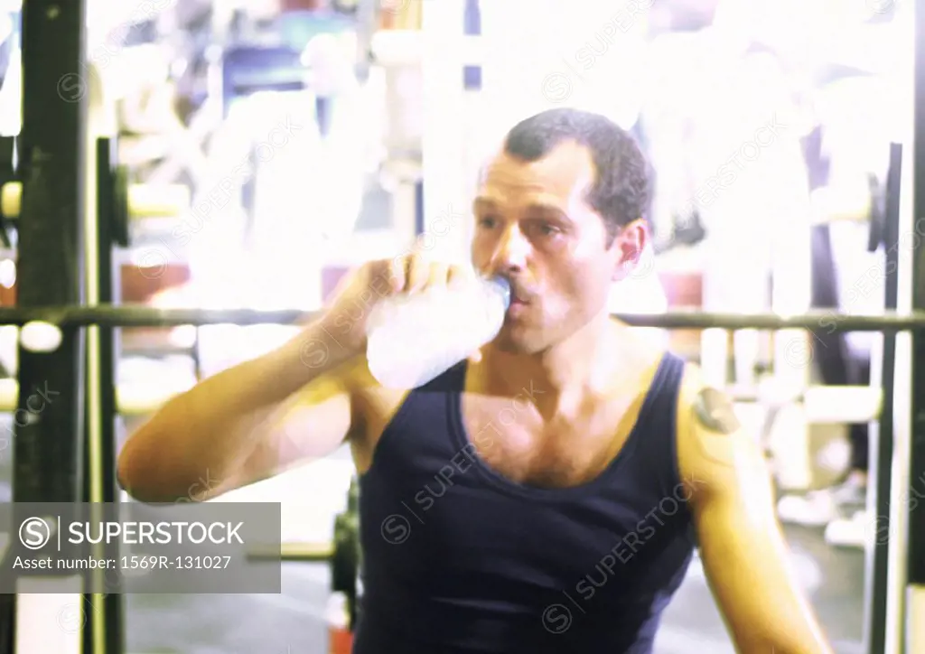 Man drinking water in gym