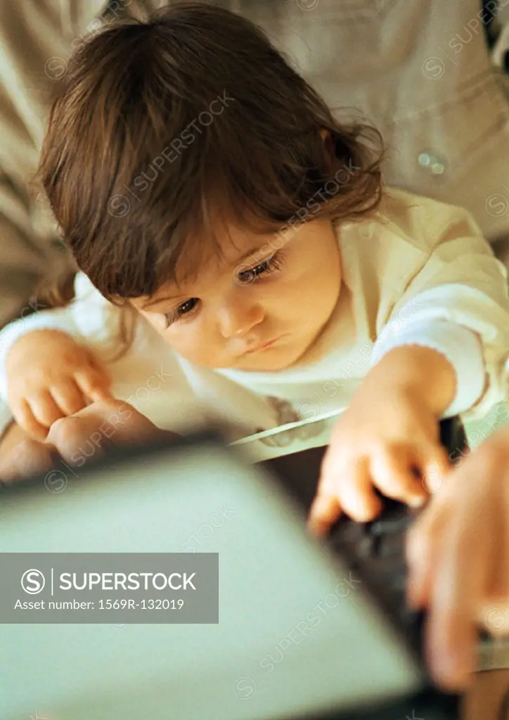 Father and baby using laptop, close-up on baby
