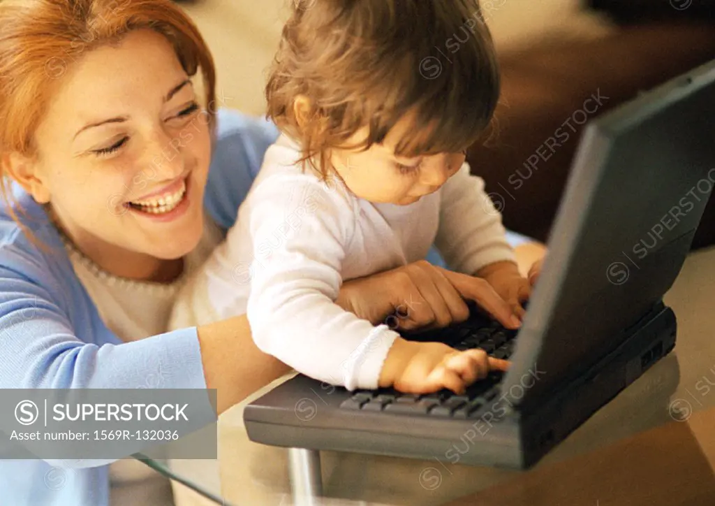 Mother and baby using laptop, portrait