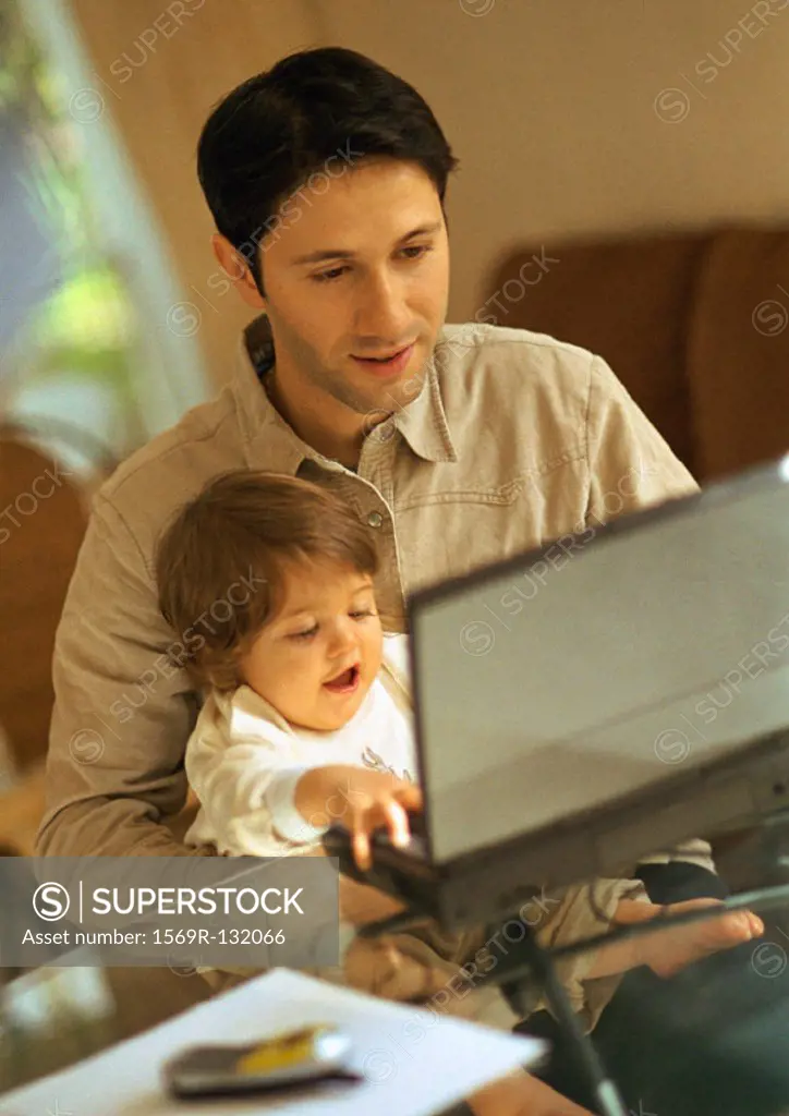 Father and baby using laptop