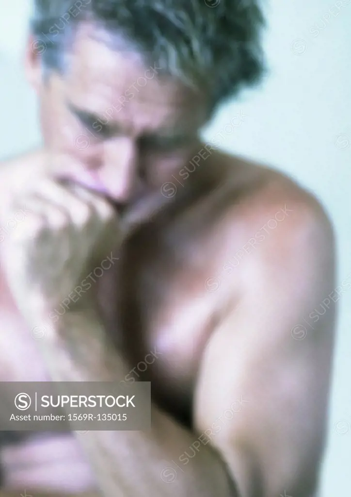 Topless mature man holding head with hand, close-up, portrait
