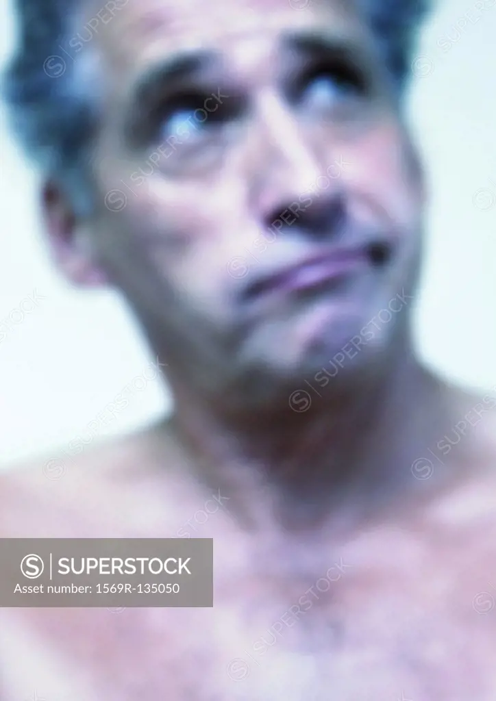 Mature man raising eyebrows, close-up, portrait, blurred