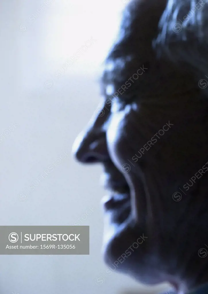 Senior man smiling, side view, close-up, portrait