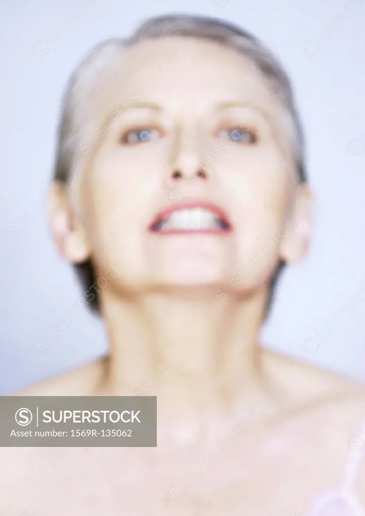 Mature woman gritting teeth, close-up, portrait