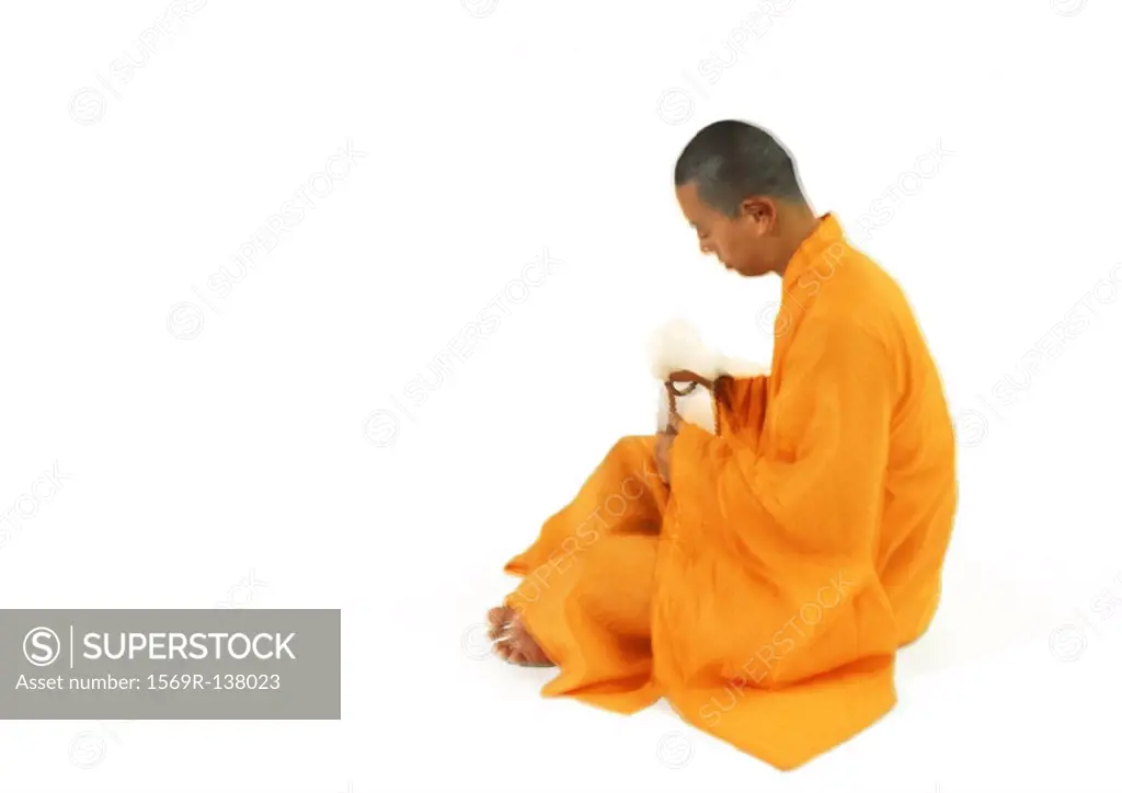 Buddhist monk sitting, side view