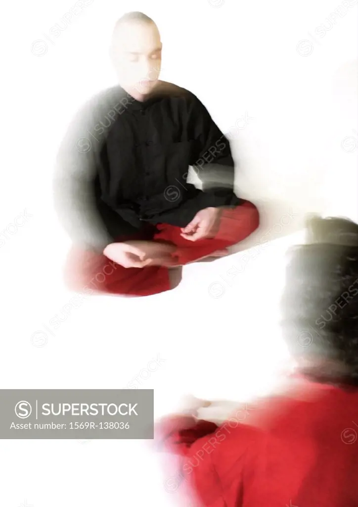 People sitting on floor indian style, meditating, blurred