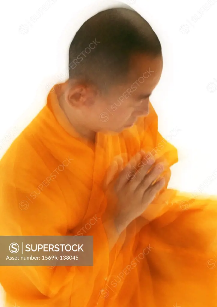 Buddhist monk meditating, blurred, high angle view