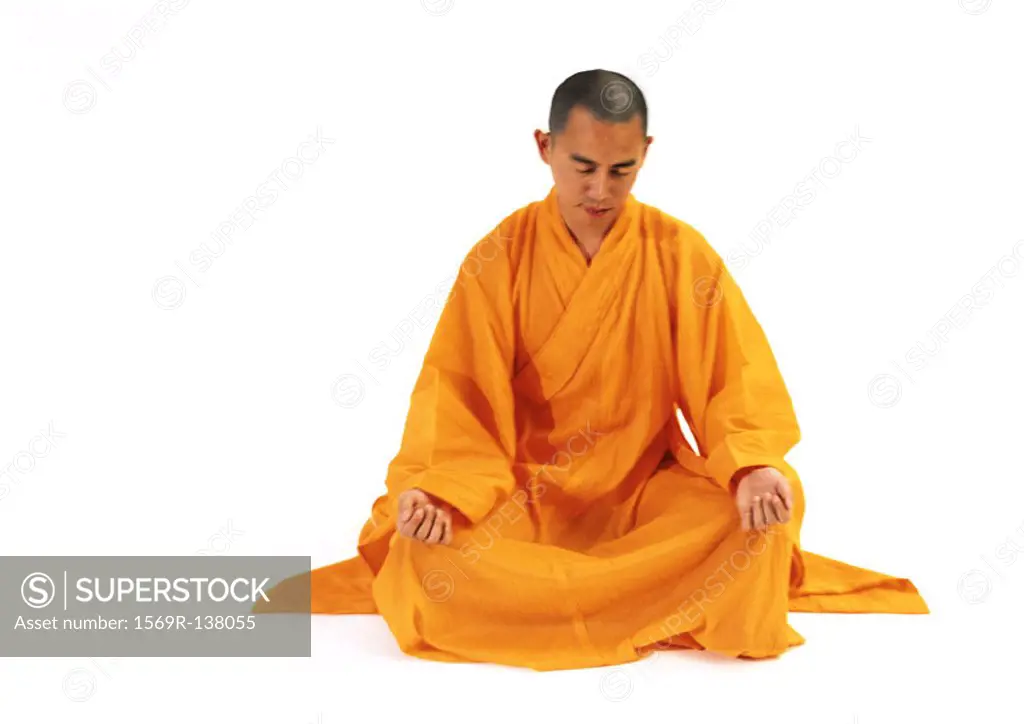 Buddhist monk meditating in lotus position