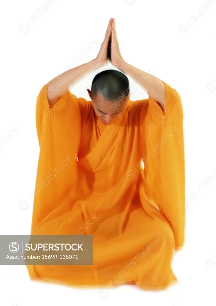 Buddhist monk meditating with hands together over head