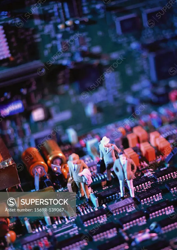 Toy figures on computer circuit board, close-up